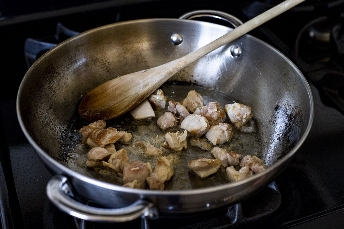 Chicken being browned in skillet.