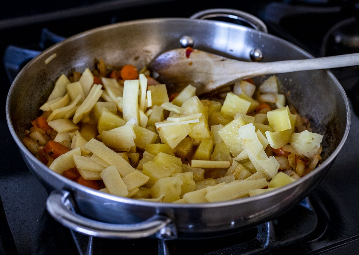 Bamboo shoots and pineapple added to the skillet.