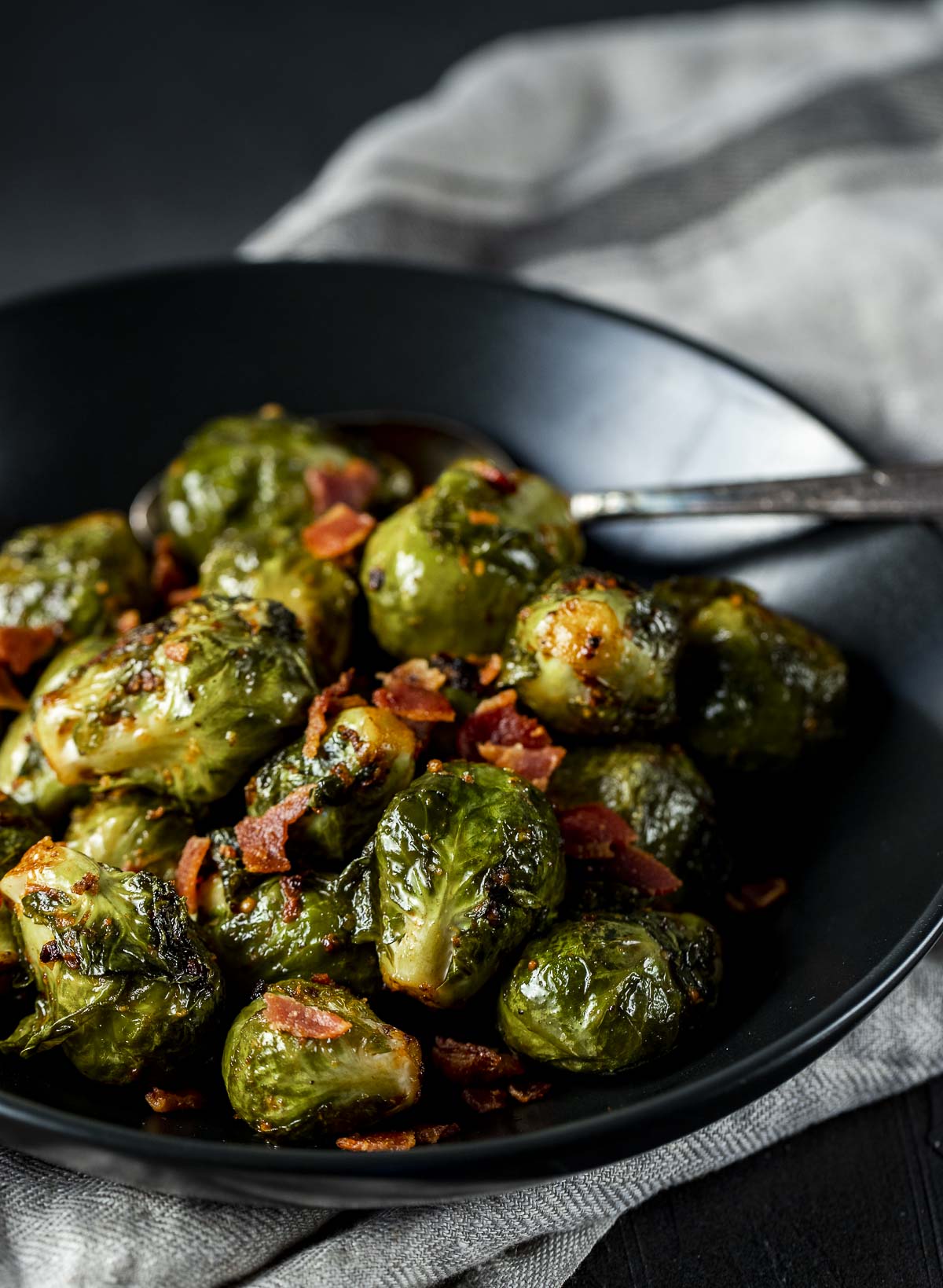 Side view of sous vide Brussels sprouts served in a black bowl.