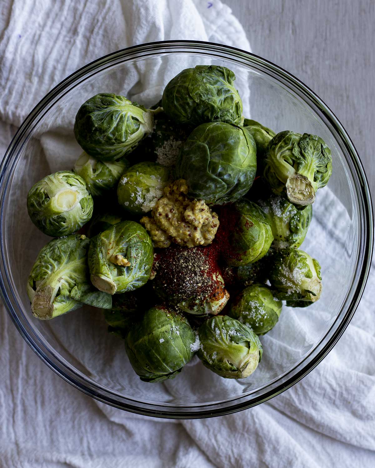Brussels sprouts mixed with the other ingredients in a glass bowl.