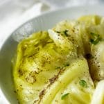 Cooked cabbage in a white bowl.