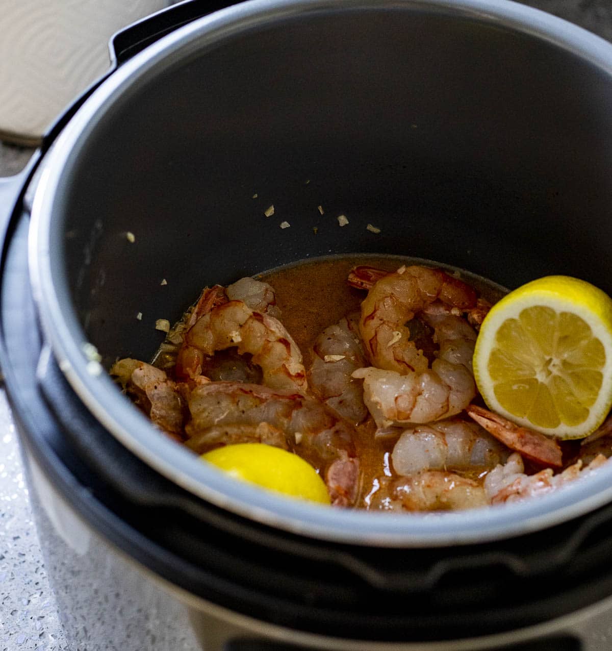 Shrimp in the Instant Pot with the sauce and lemon halves.