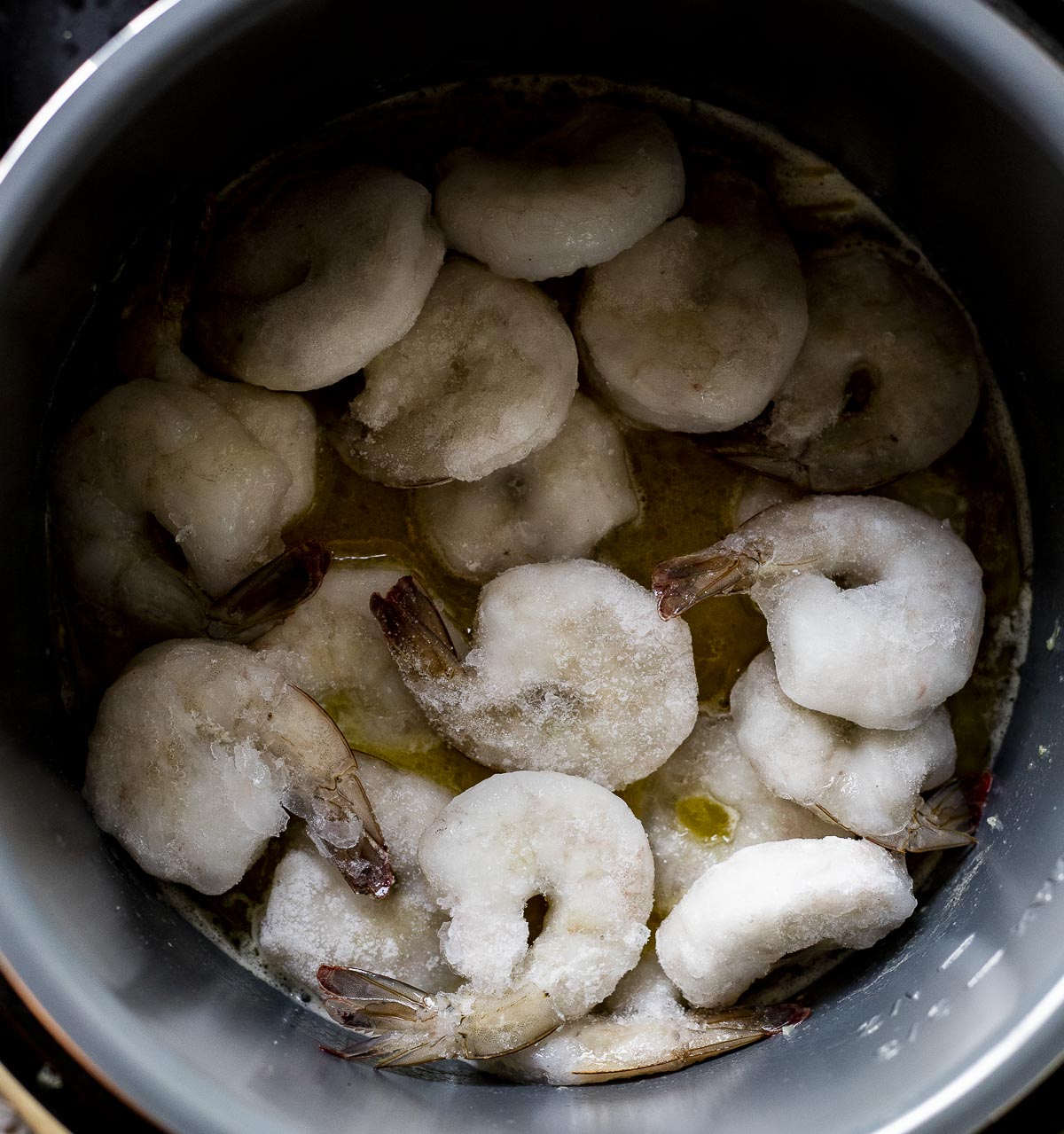 Frozen shrimp added to the Instant Pot insert.