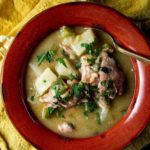 Overhead of southern stewed chicken in a red bowl.
