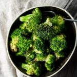 Overhead of air fried broccoli in a bowl.