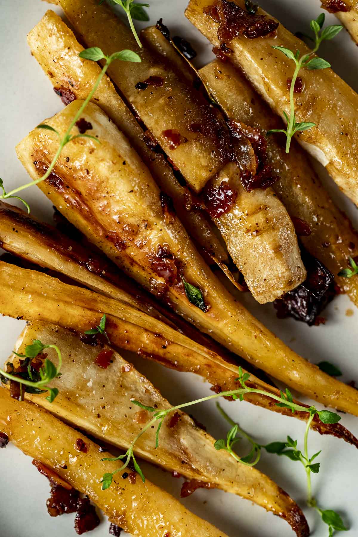 Up close view of roasted parsnips arranged on a plate.