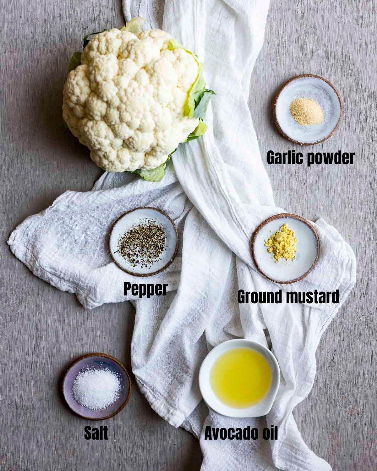 Ingredients to make air fryer cauliflower arranged individually and labelled.