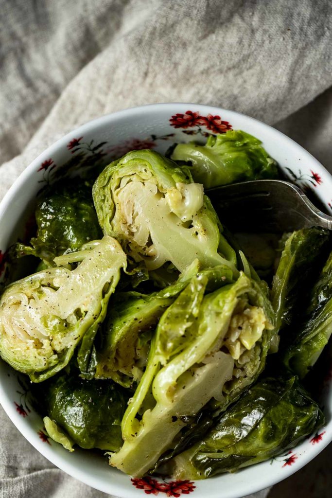 Up close overhead view of cooked brussels sprouts in a bowl.