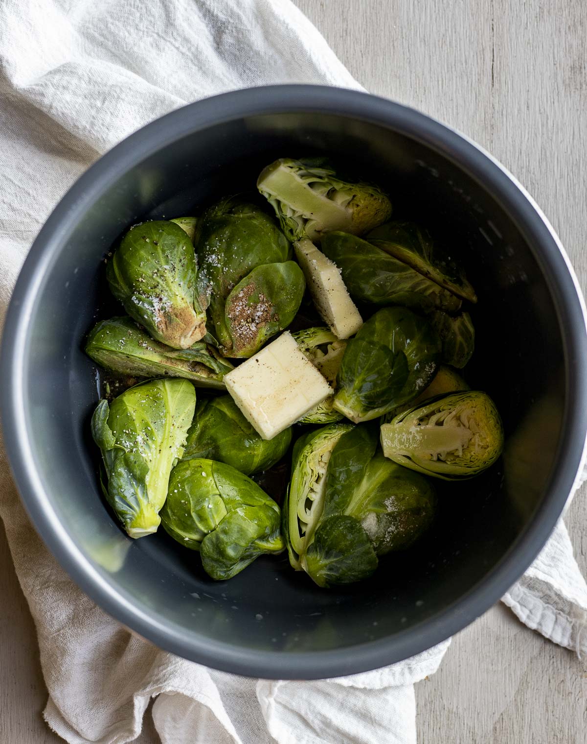Raw brussels sprouts and other ingredients placed in the Instant Pot insert.