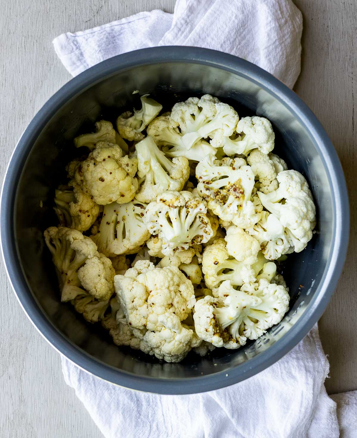 Raw cauliflower florets added to the Instant Pot insert.