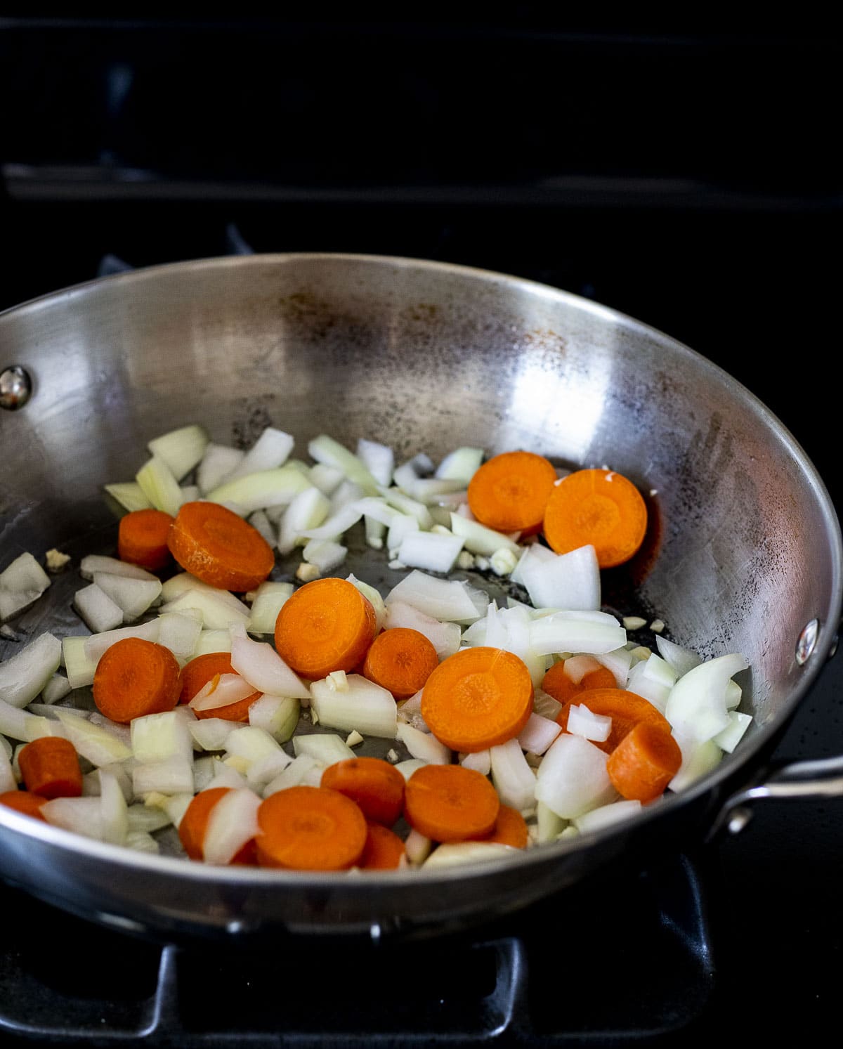 Raw and chopped carrot, onion and garlic in a large skillet.