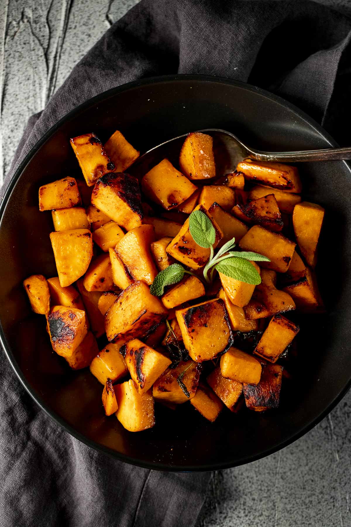 Overhead of sweet potato cubes served in a black bowl.