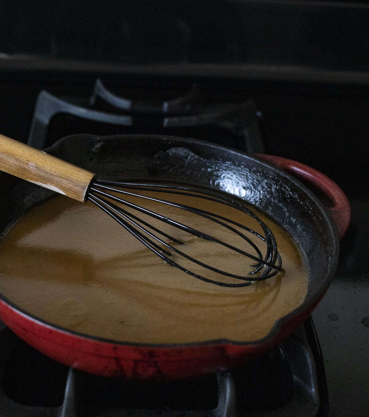 Gravy being whisked together in a skillet.