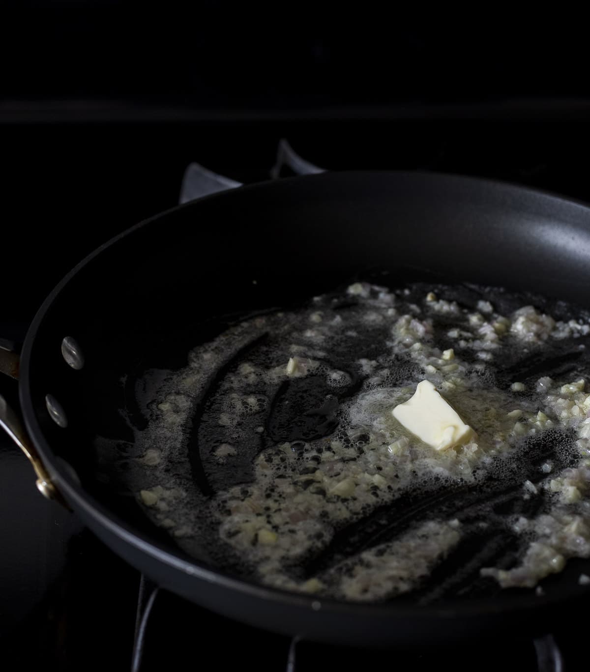 Butter, garlic and shallots cooking in a skillet.