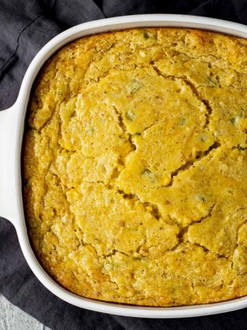 Overhead view of a baked cornbread pudding in a casserole dish.