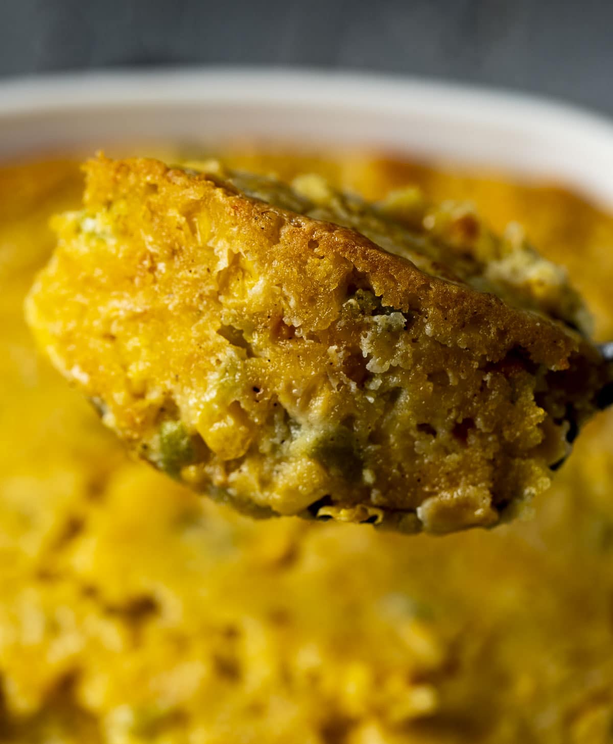 Close up view of a spoonful of cornbread pudding.