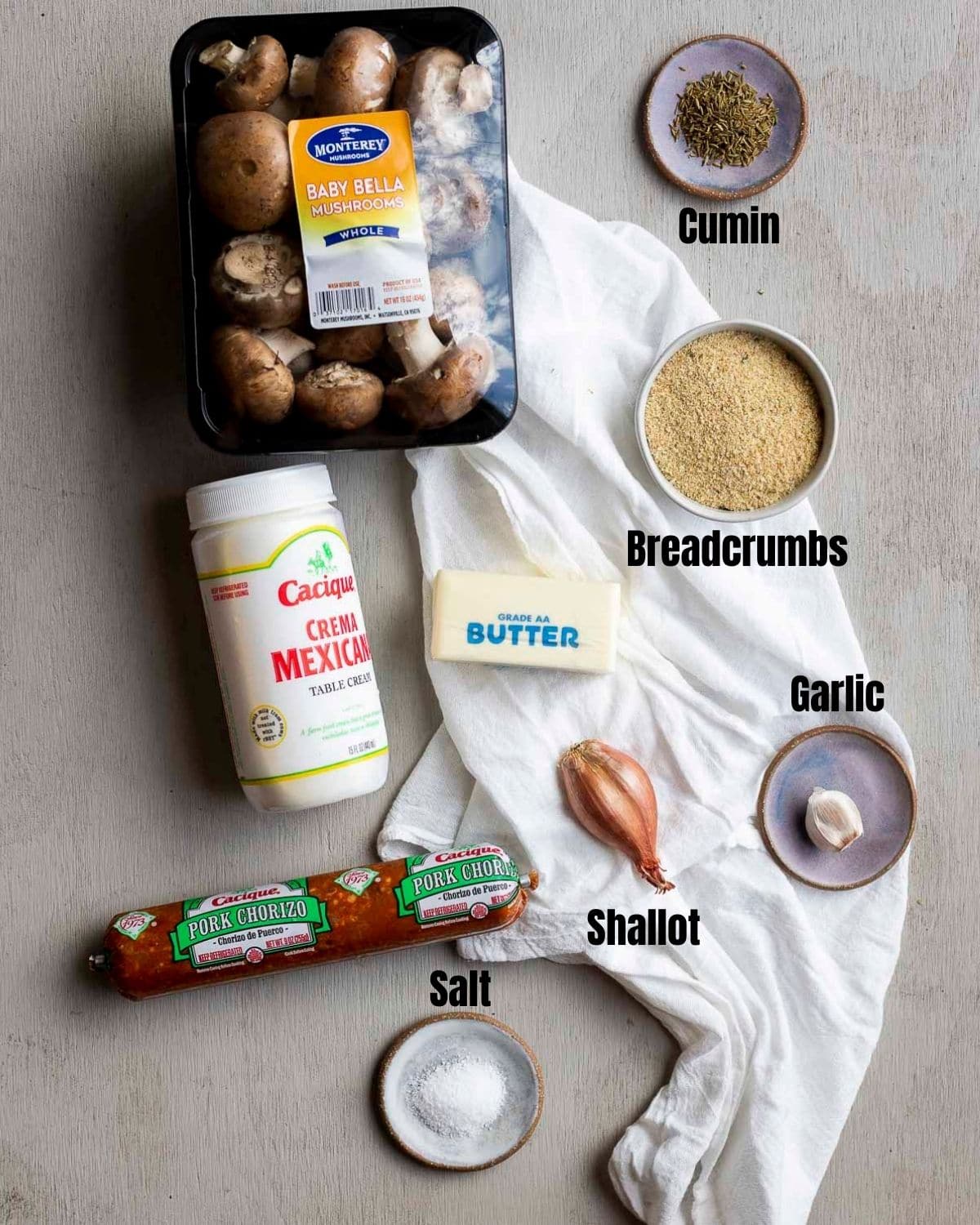 Ingredients to make air fryer stuffed mushrooms arranged individually and labelled.