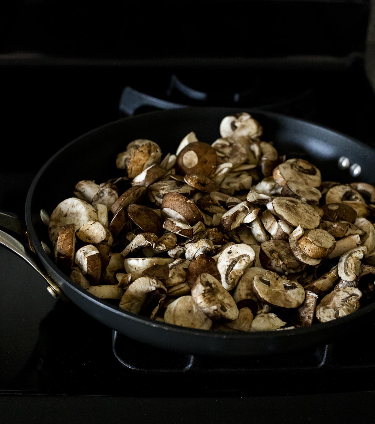 Mushrooms sauteing in a skillet.