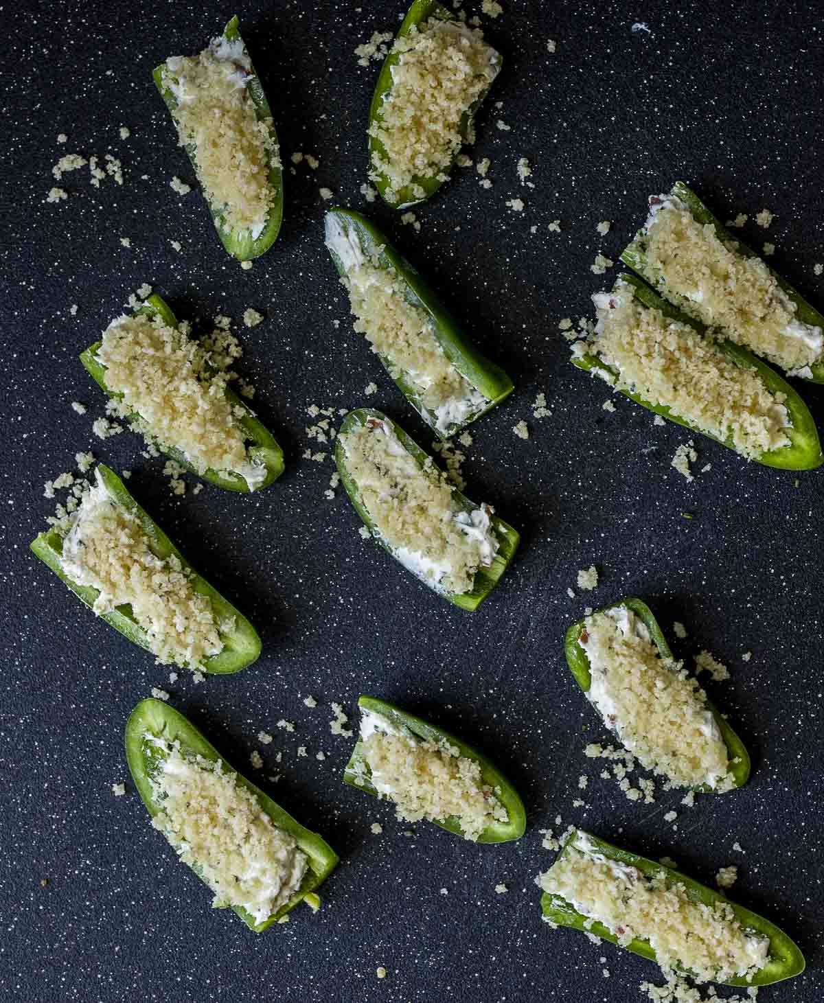 Jalapeños stuffed with filling and topped with the bread crumb mixture.