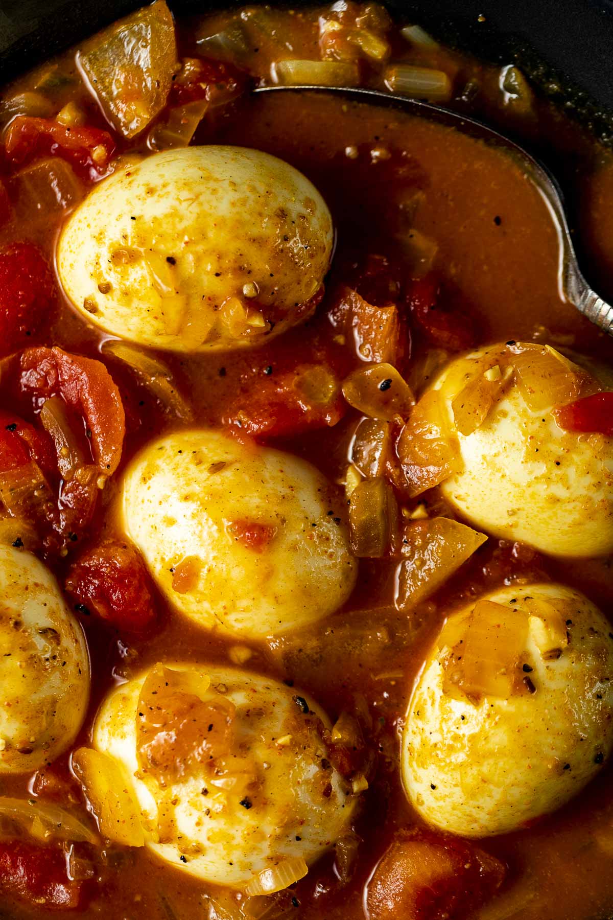 Close up of eggs in tomato and onion sauce.