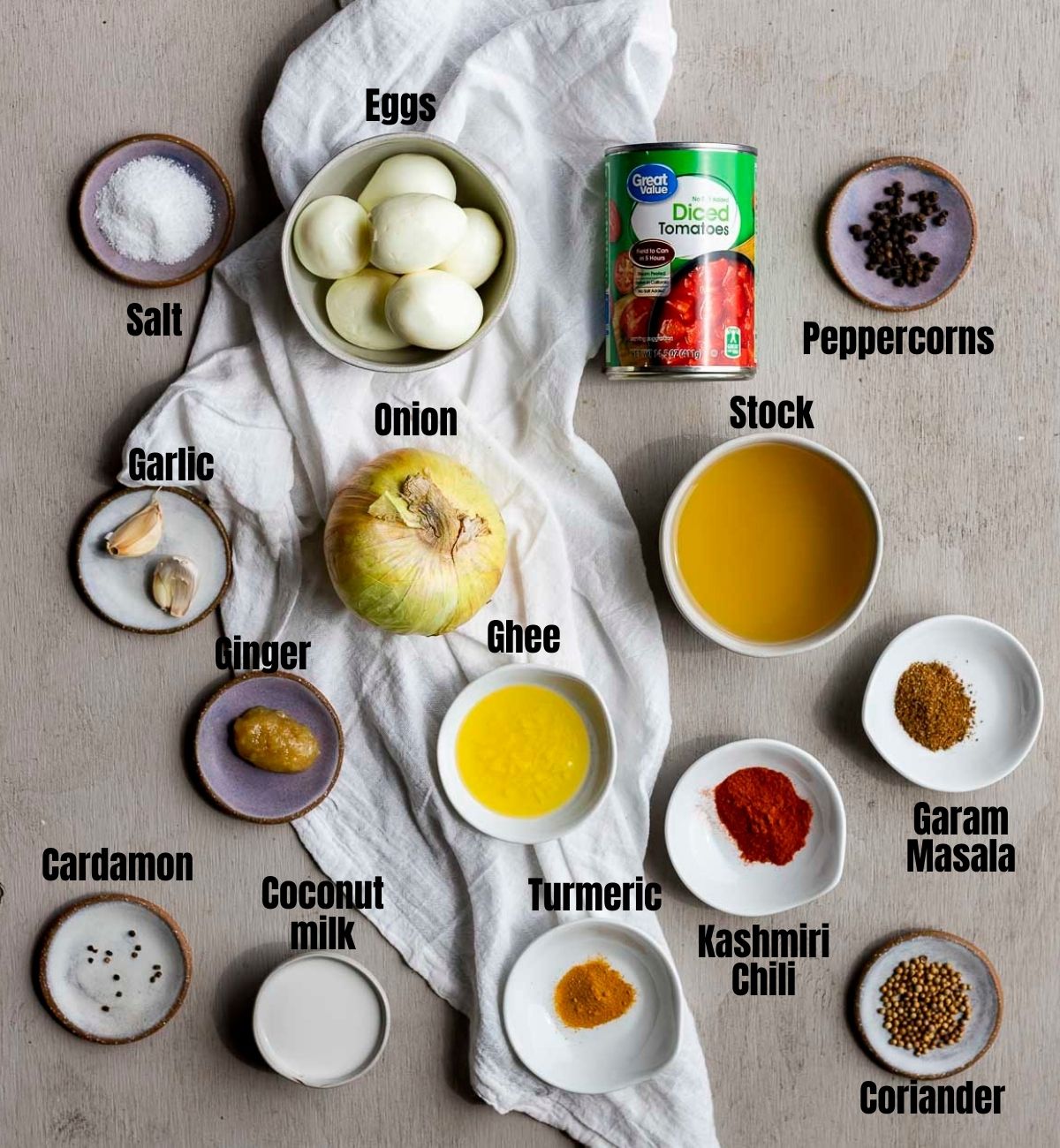 Ingredients to make egg curry arranged individually and labelled.