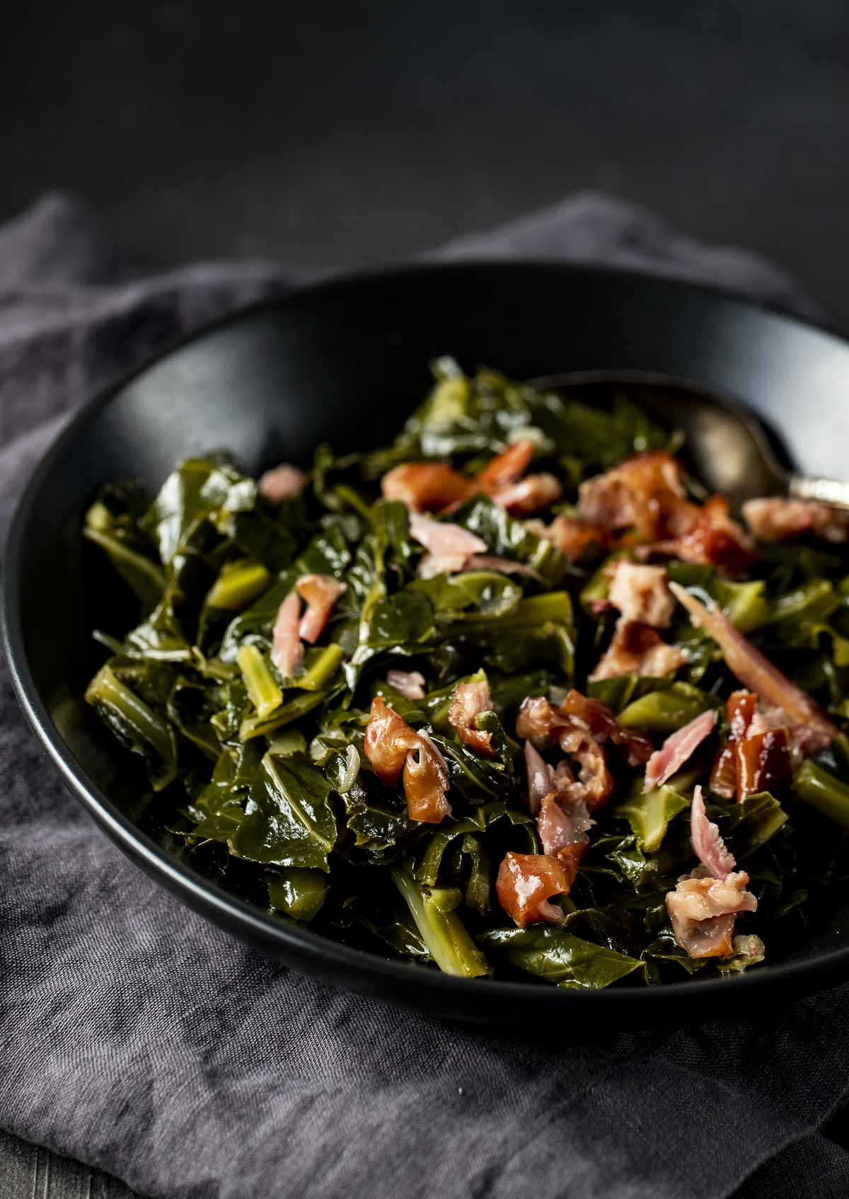 Instant Pot collard greens with shredded smoked turkey served in a black bowl.