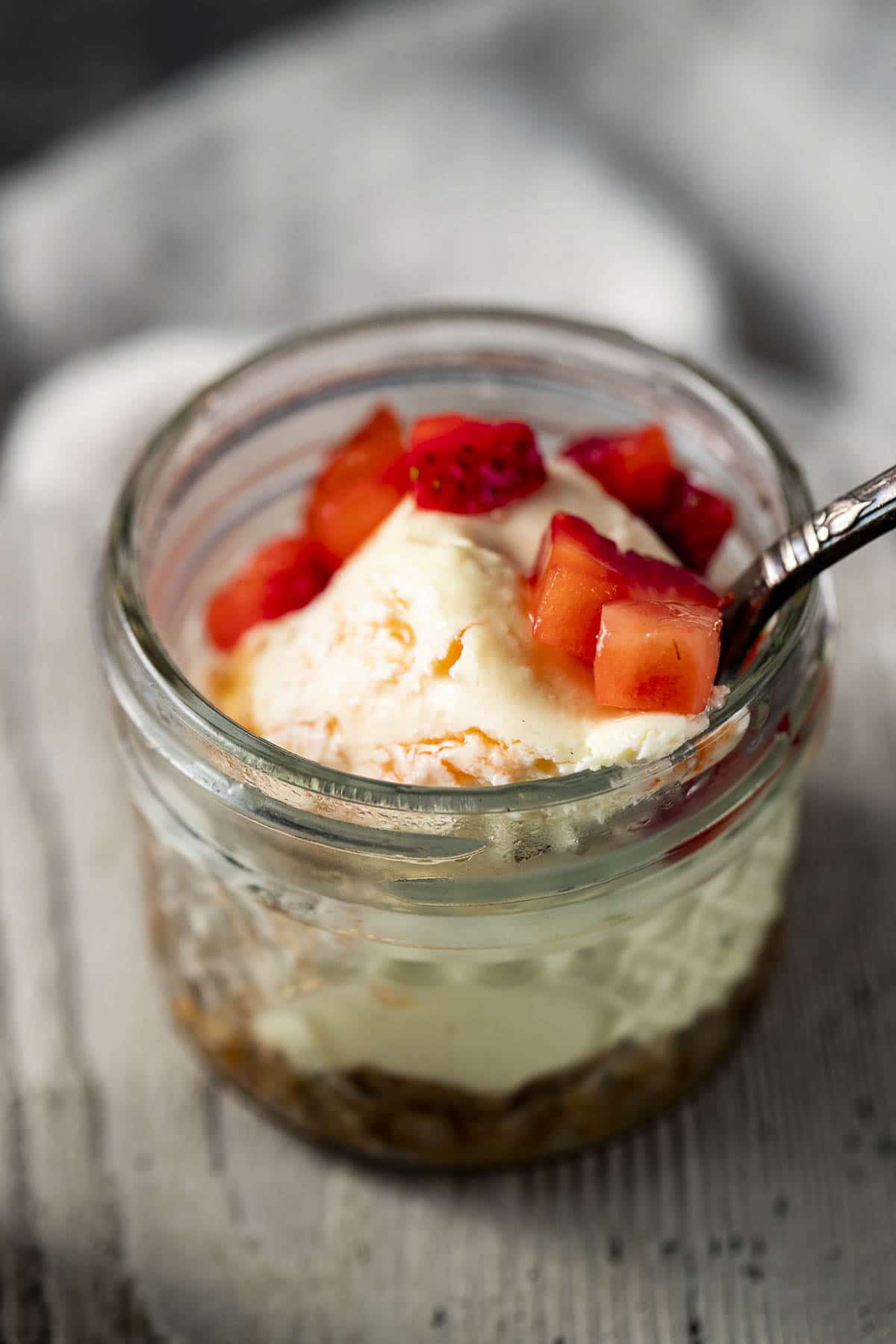 Side view of a sous vide cheesecake in a mini glass jar.