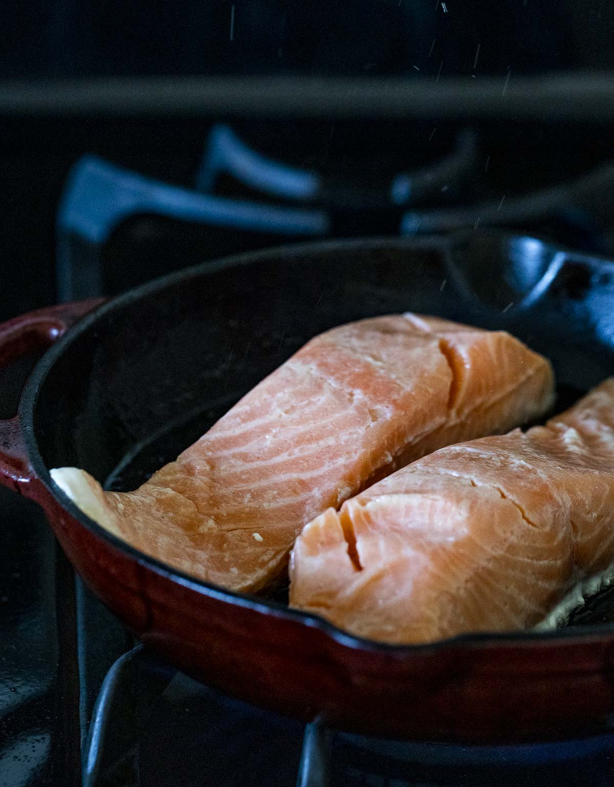 Sous vide salmon portions being seared in a skillet.