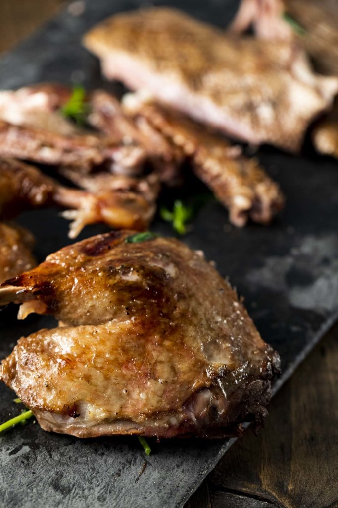 Side view of pieces of carved duck arranged on a pan.