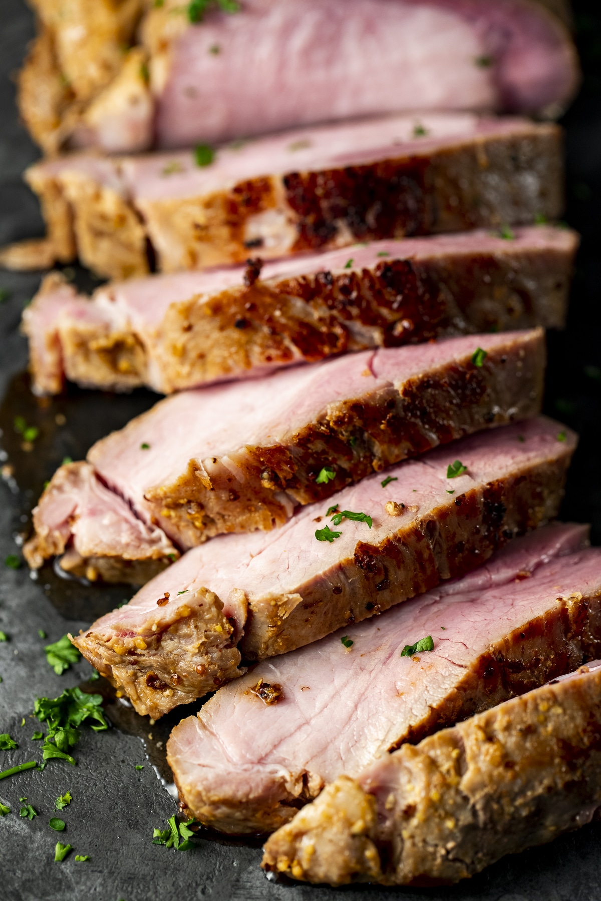 Slices of pork loin roast garnished with fresh parsley.