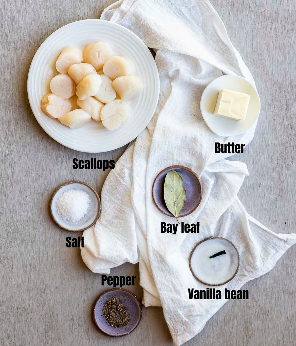 Ingredients to make broiled scallops arranged individually and labelled.