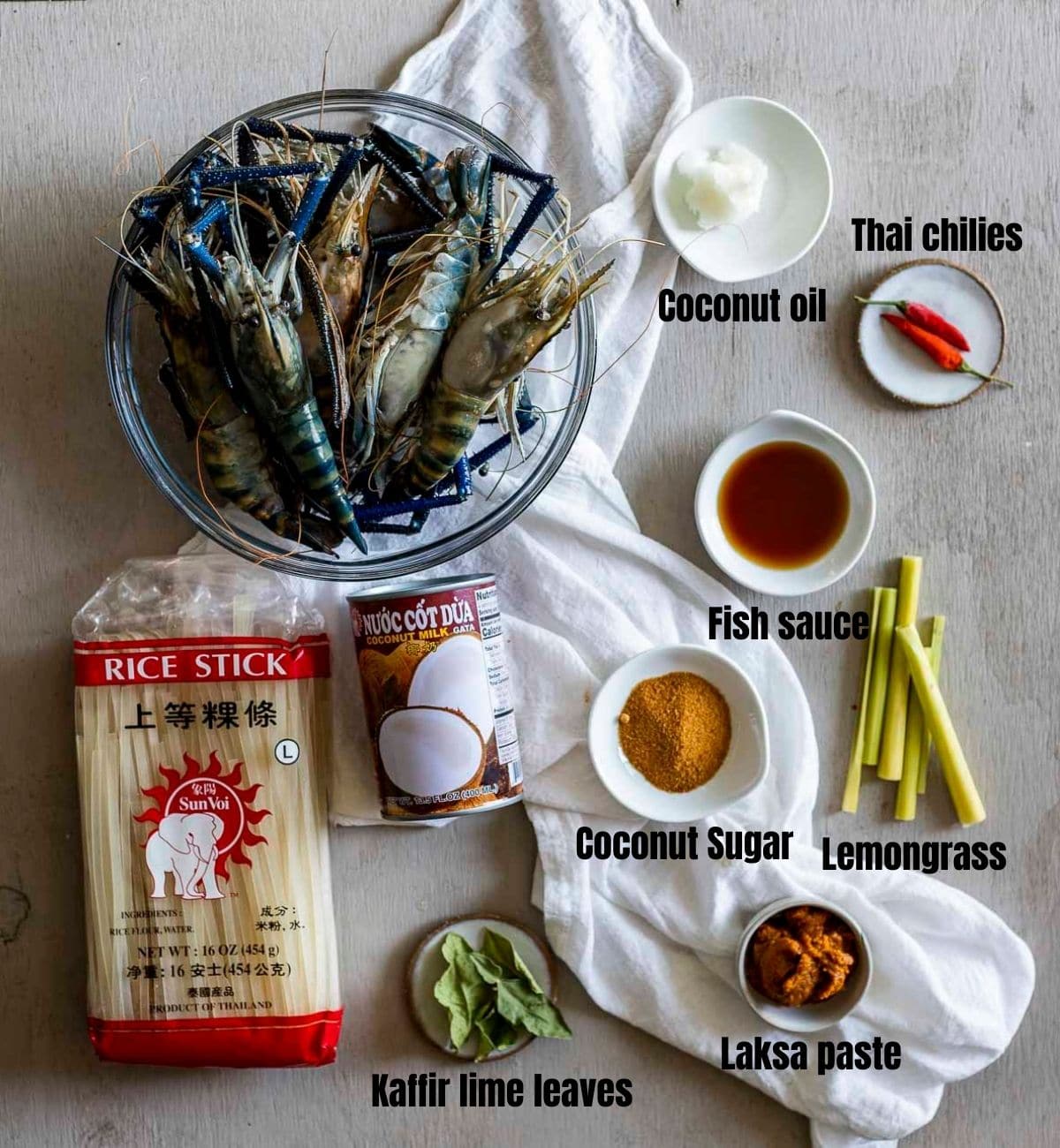 Ingredients to make prawn laksa arranged individually and labelled.