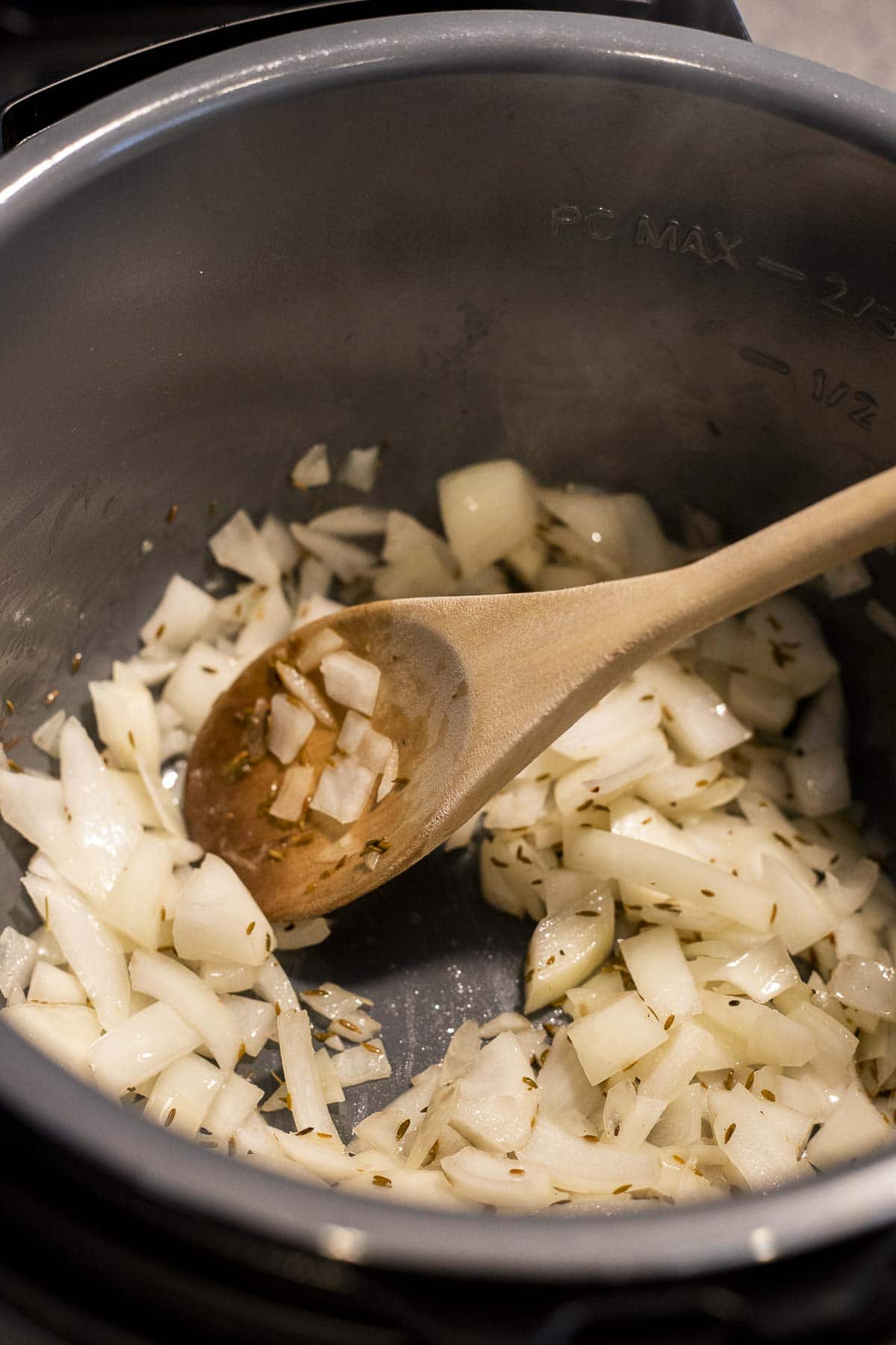 Onions sautéing in bacon fat in an Instant Pot insert.