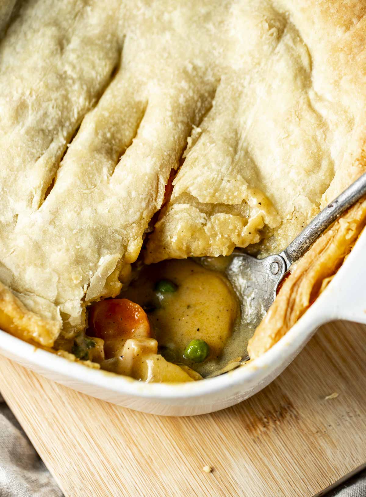 Serving spoon inserted into a chicken pot pie.