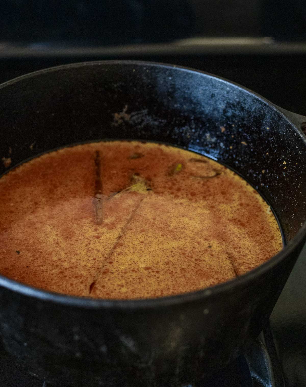 Laksa broth in a large pot with coconut milk mixed in.