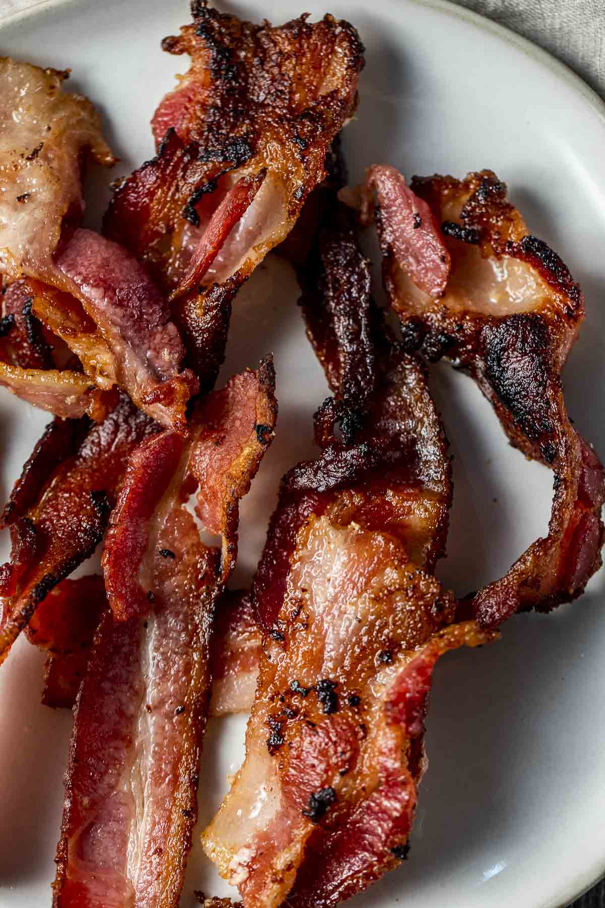 Close up view of crispy bacon on a plate.