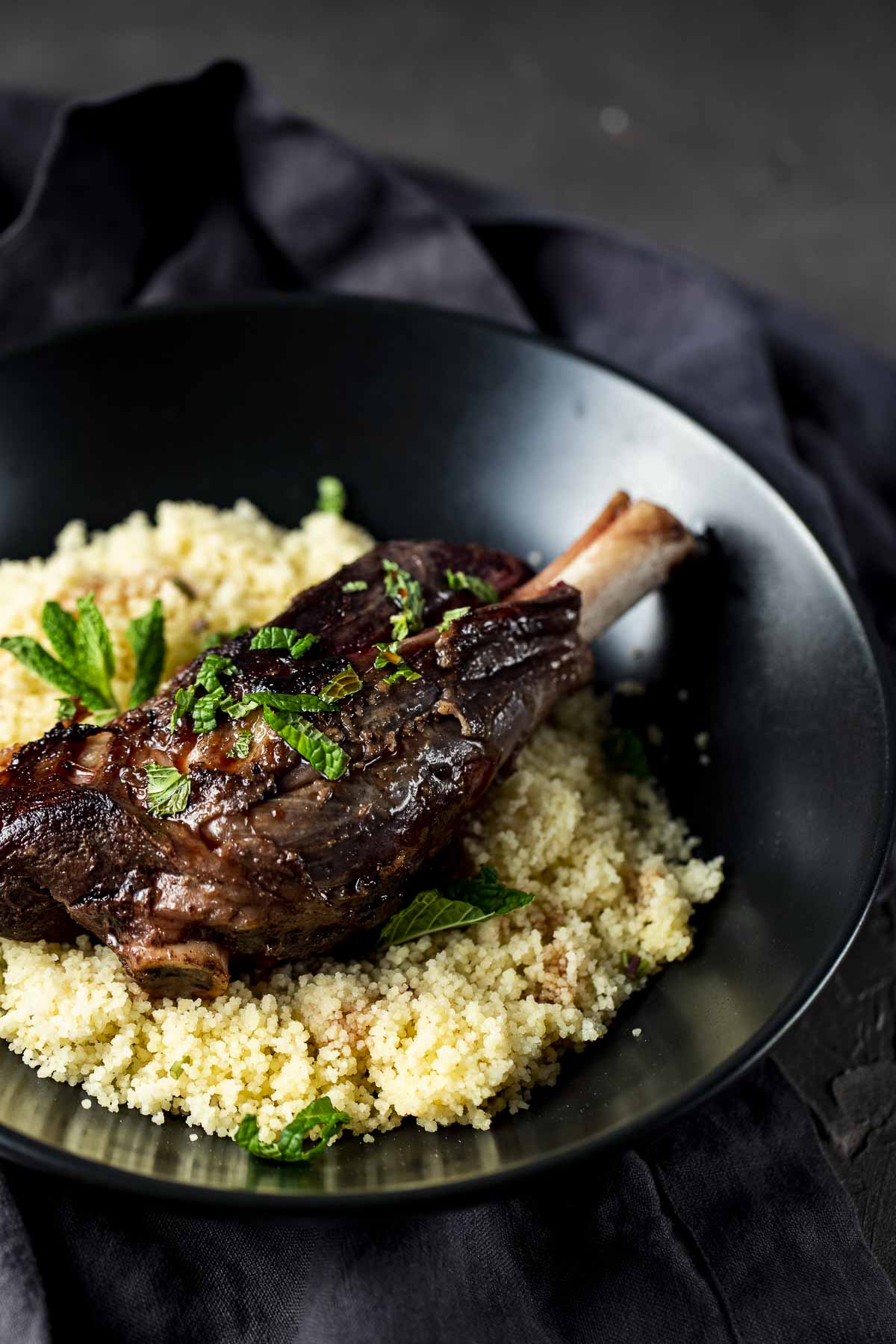Lamb shank served with fresh mint and couscous.