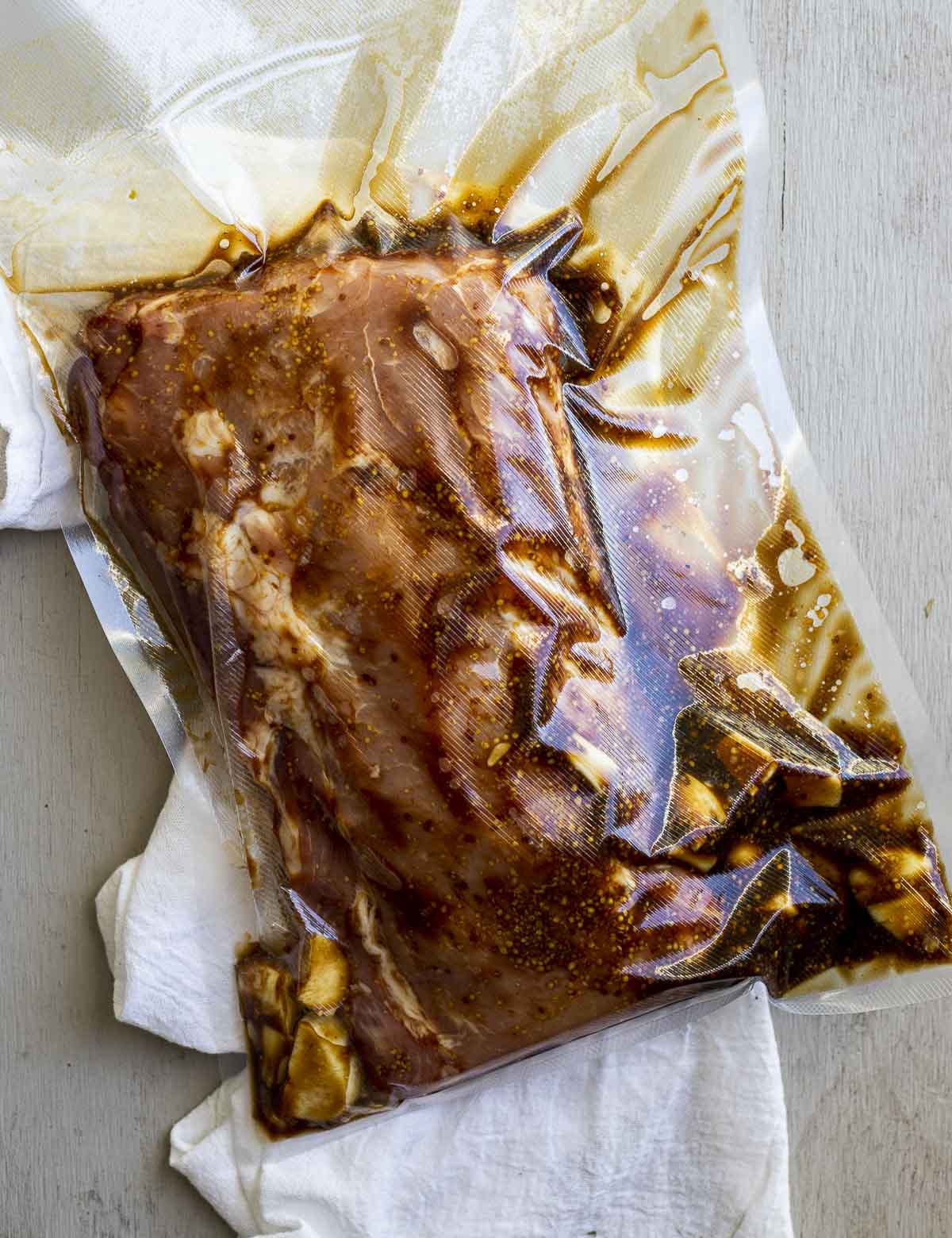 Pork roast sealed in a vacuum sealed bag with the marinade ingredients.