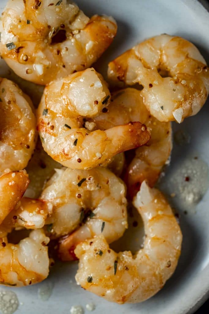 Overhead and close up view of sous vide shrimp on a plate.
