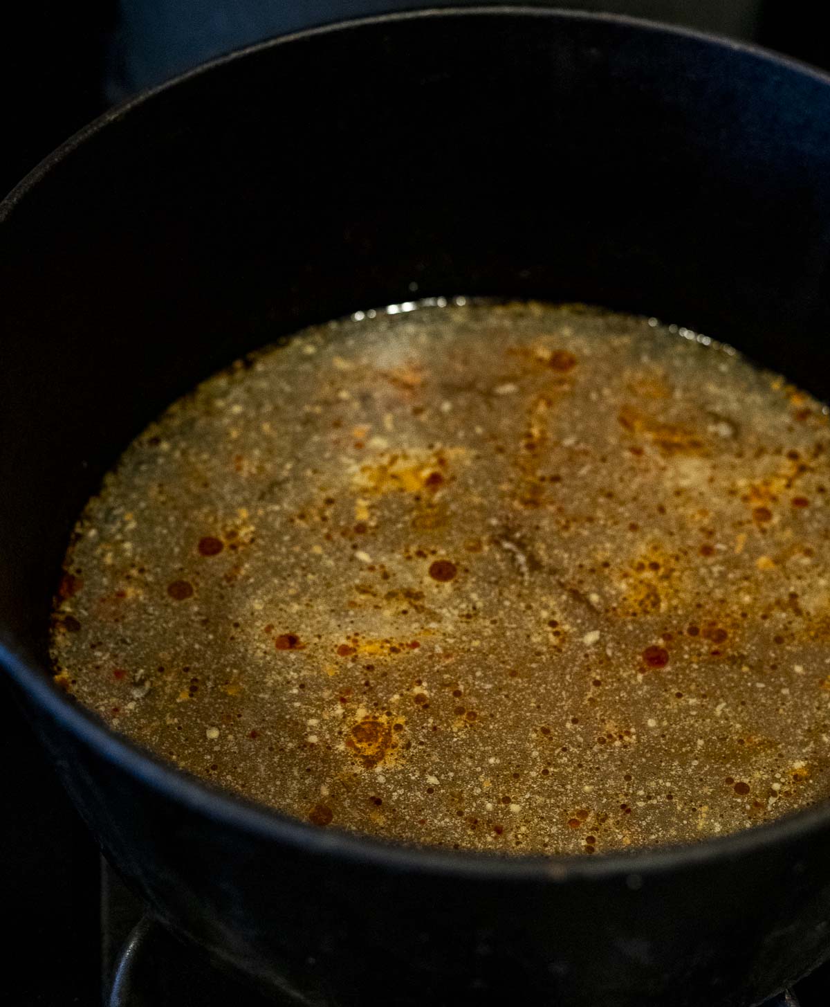 Ramen broth simmering in a large pot.