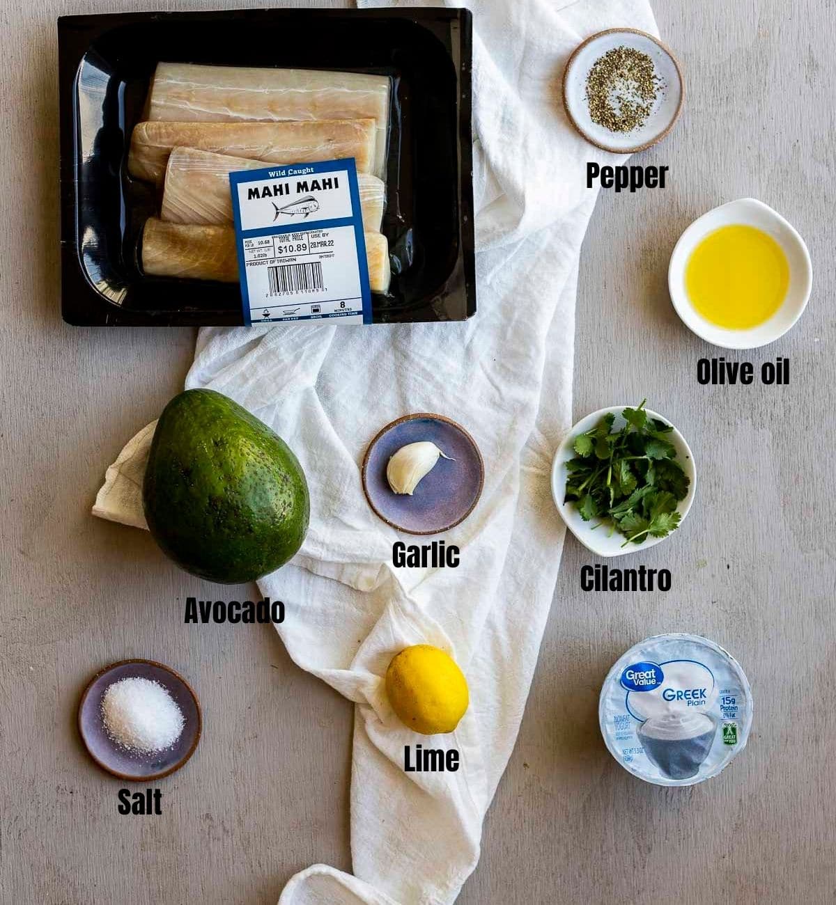 Ingredients to make sous vide mahi mahi with avocado cilantro cream sauce arranged individually and labeled.