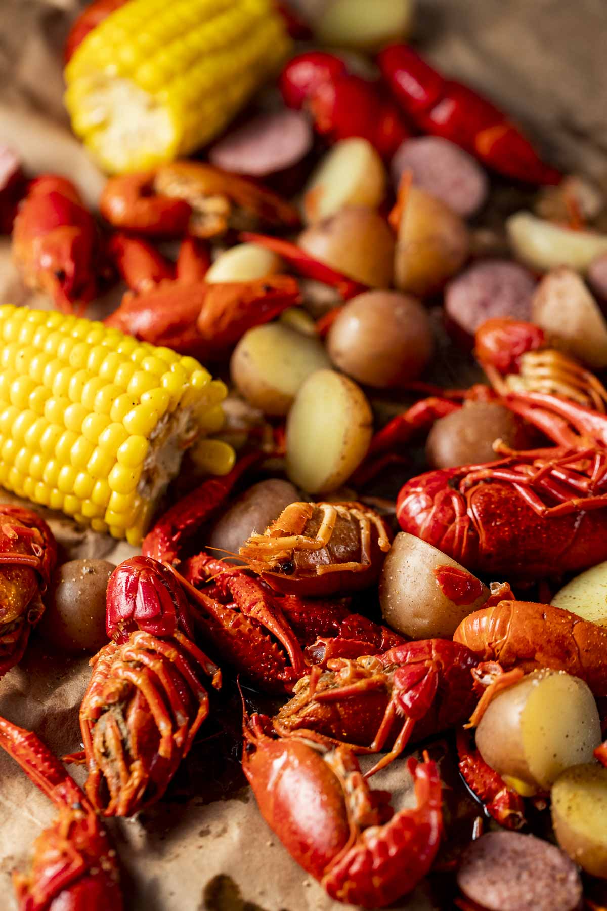Close up view of cooked crawfish with corn and potatoes.