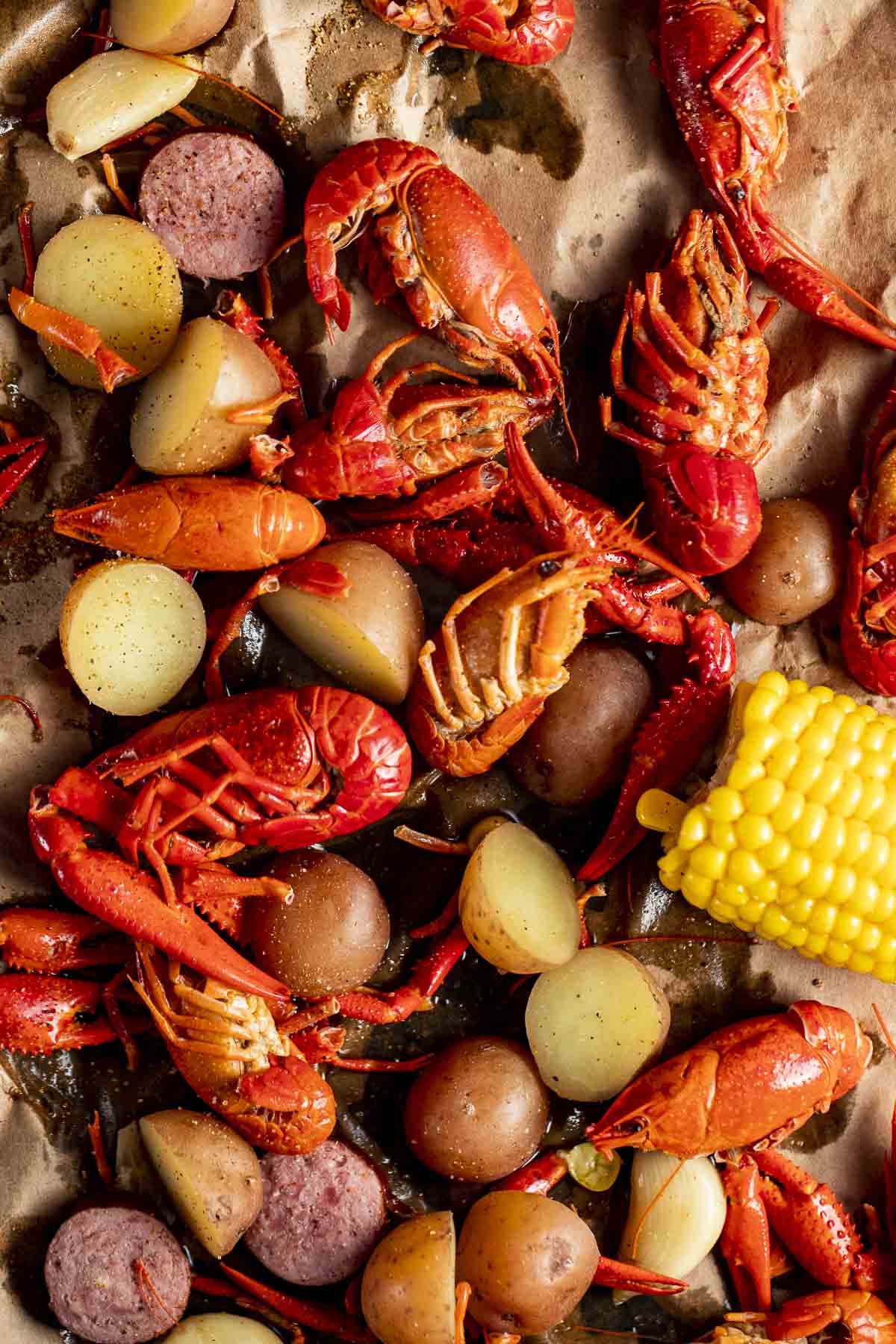 Overhead view of crawfish boil on brown paper.