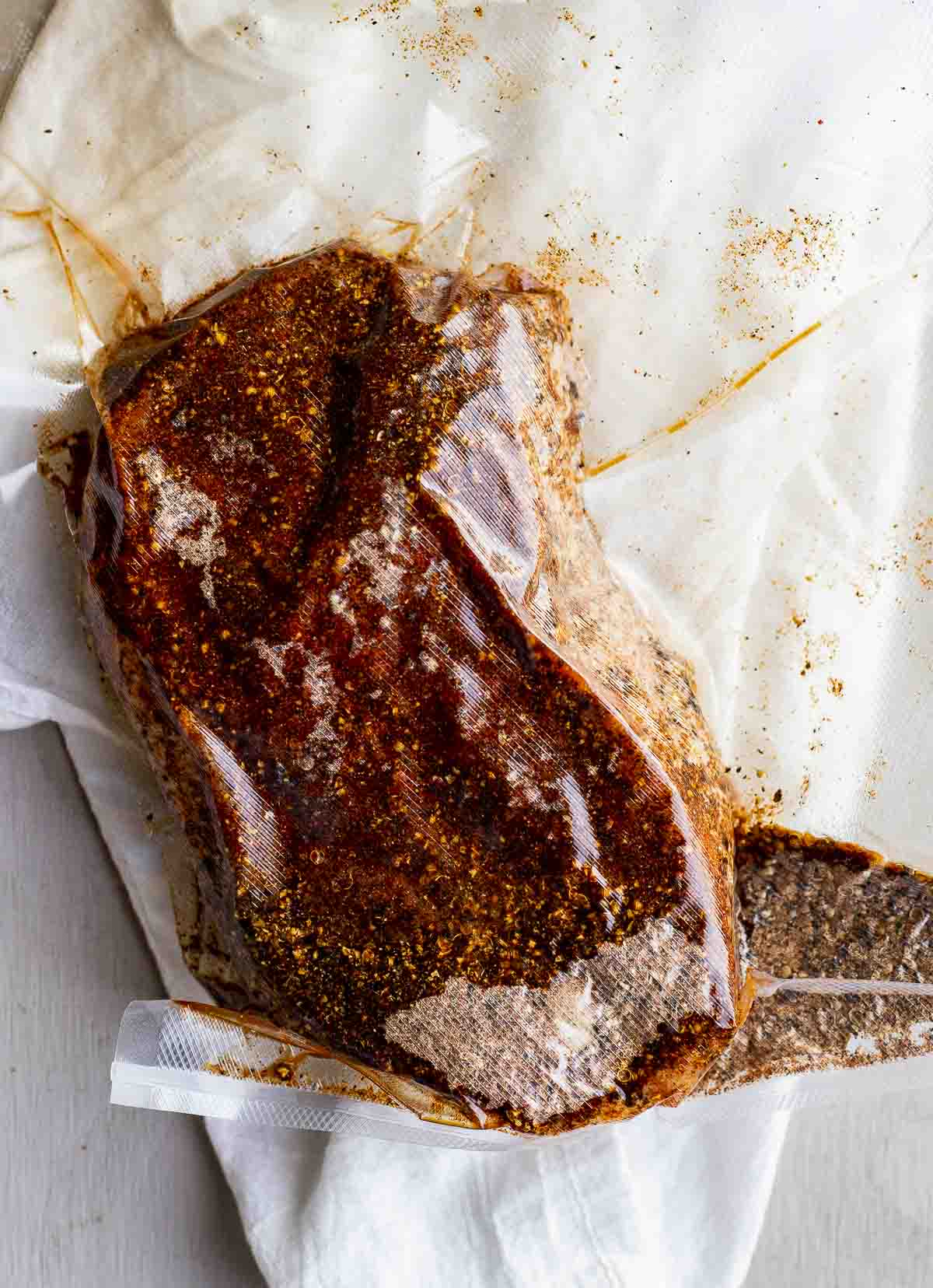 Corned beef brisket coated in spice rub and sealed in a bag.