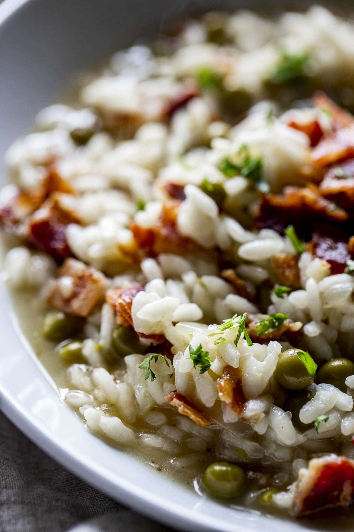 Close up view of risotto in a white bowl.