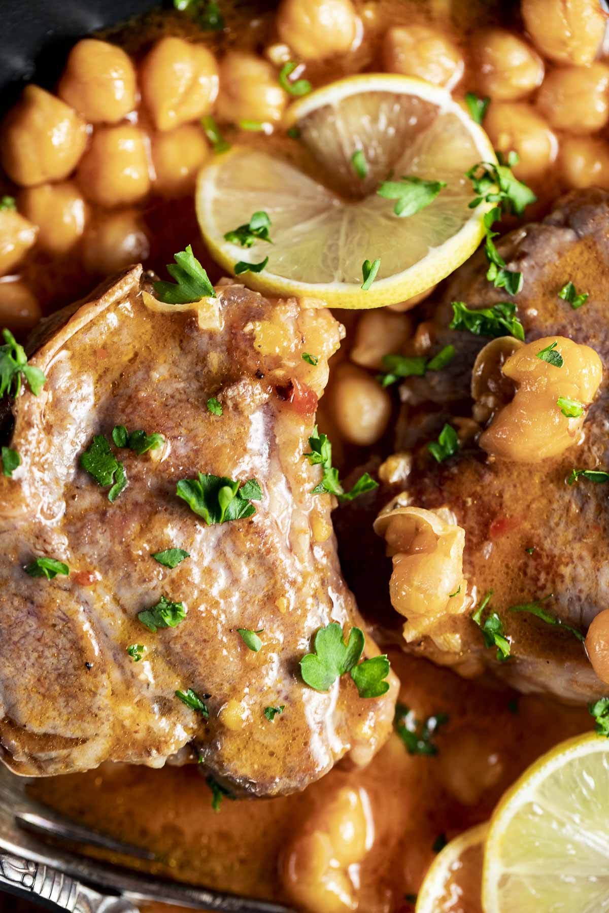 Close up view of lamb chops and chickpeas in a bowl.