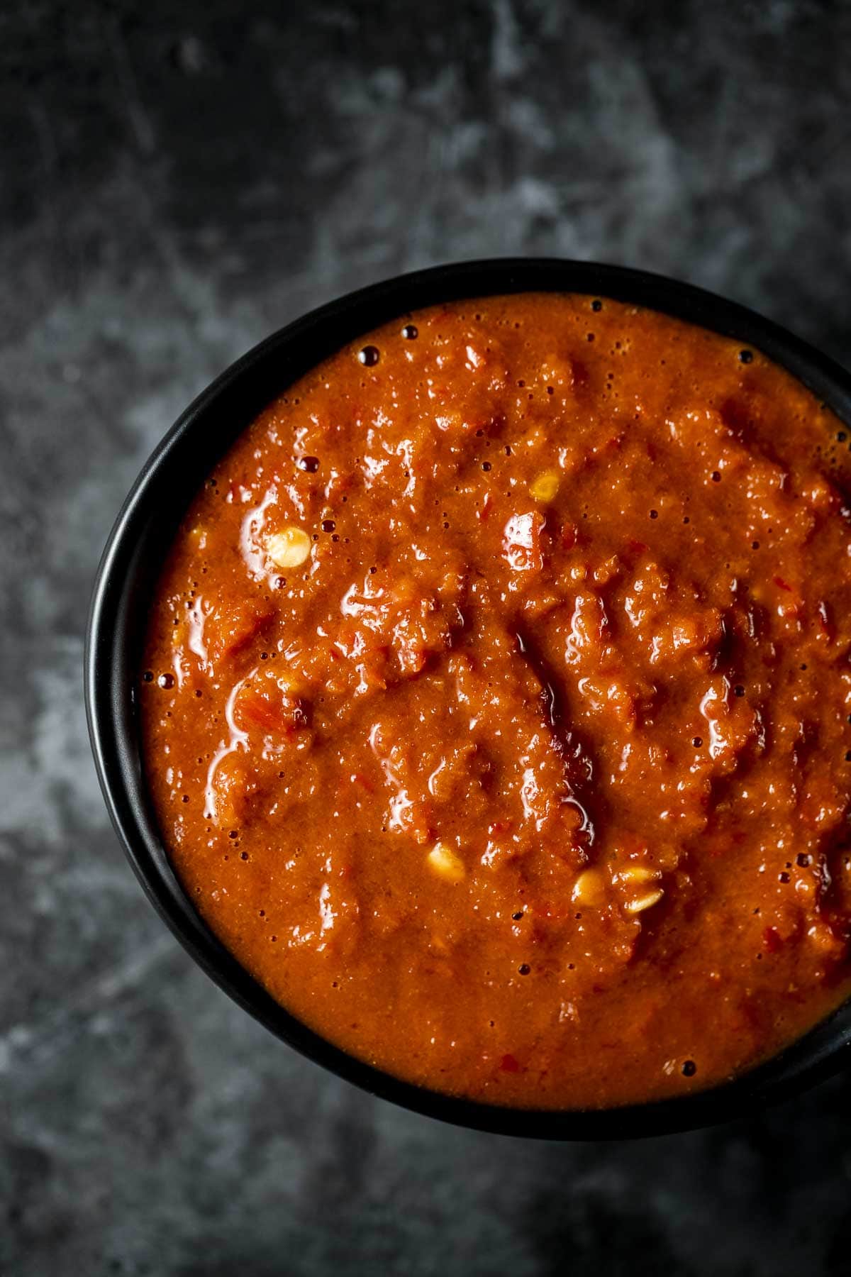 Overhead view of sambal belacan in a black bowl.