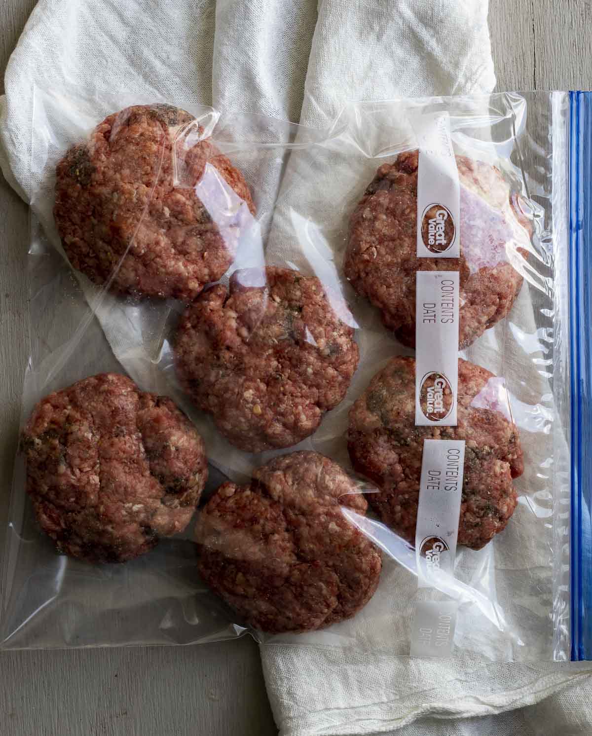 Raw burger patties in a large zip lock bag.