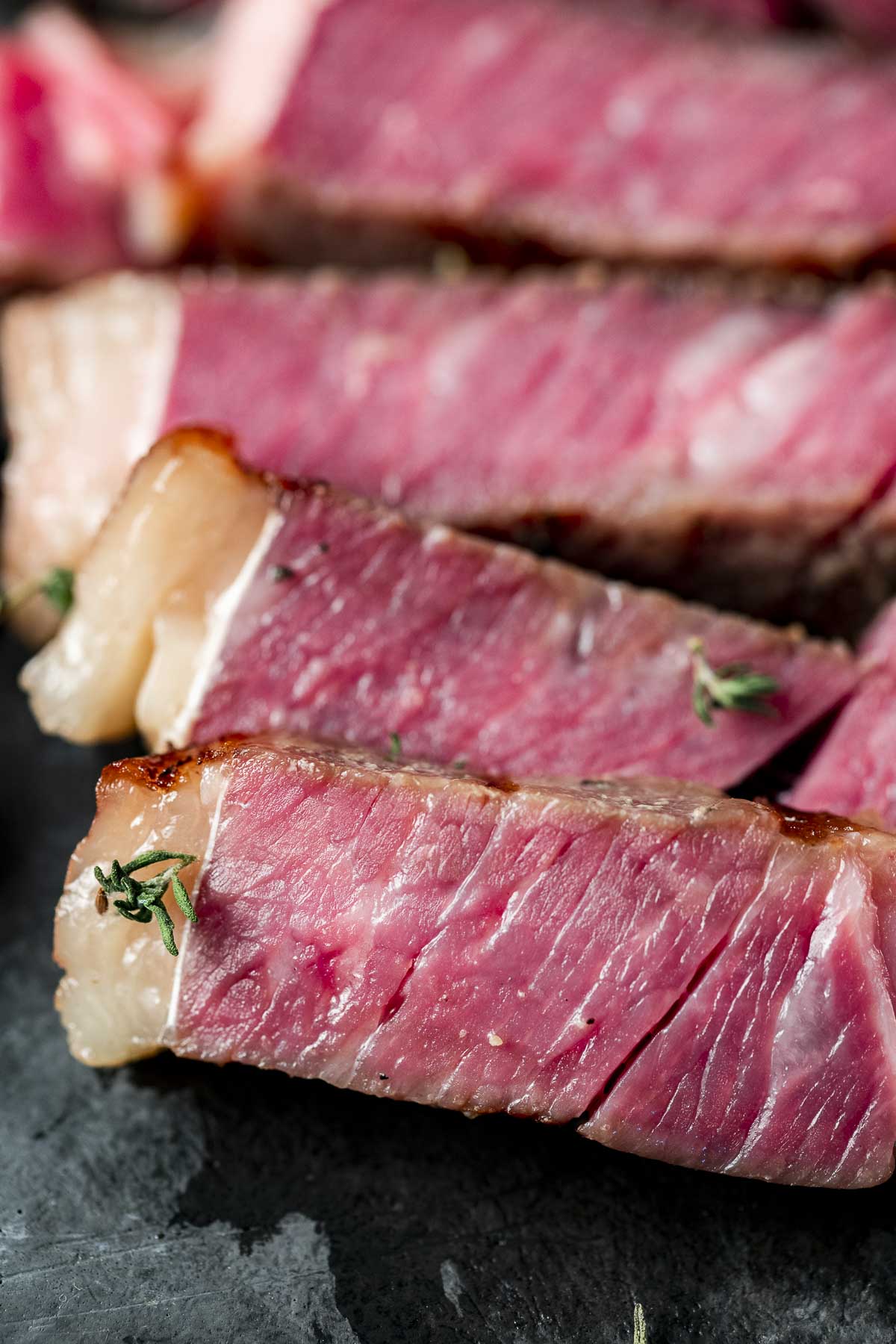 Close up view of medium rare slices of ribeye steak.