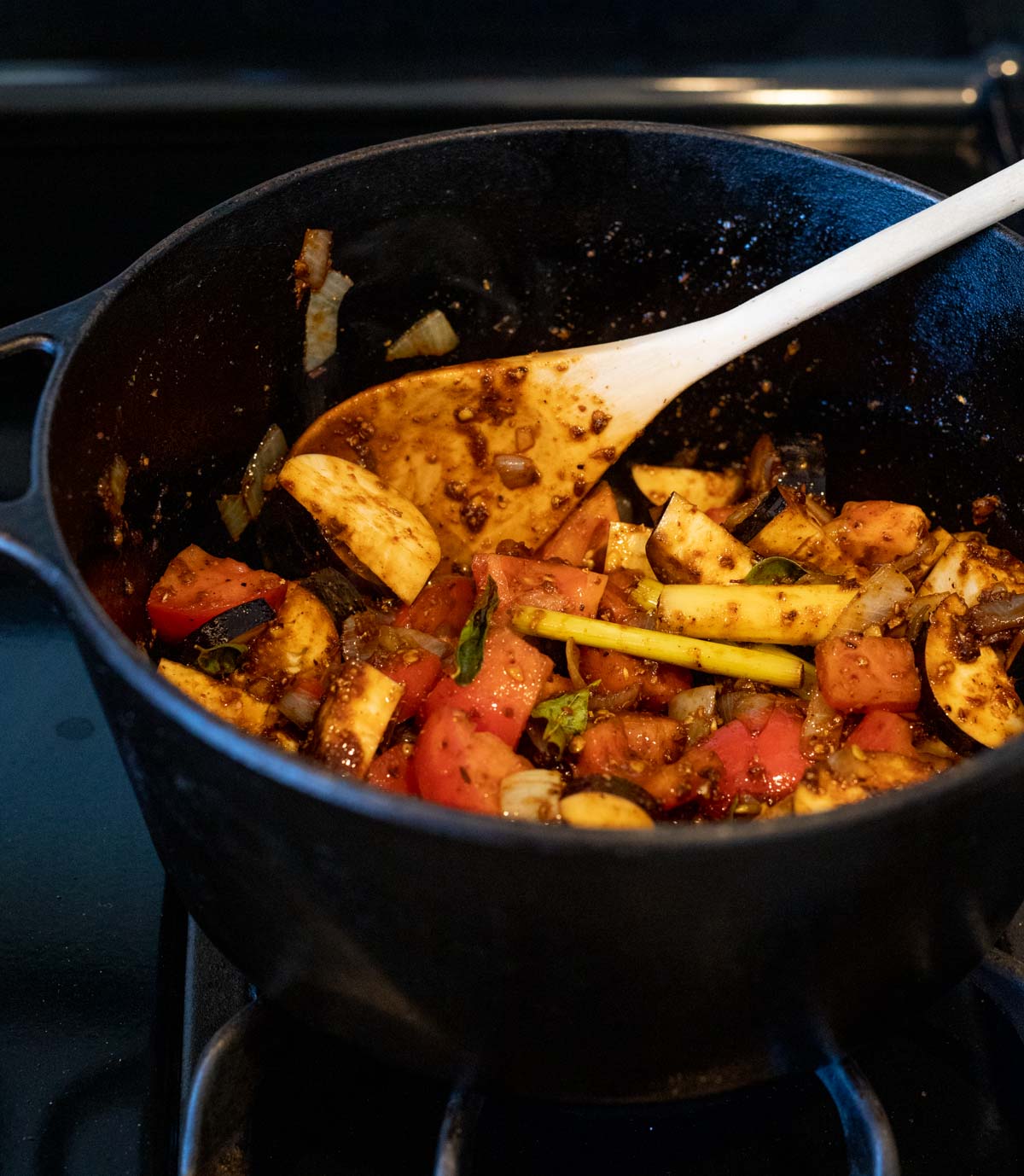 Spices, eggplant, tomato and other ingredients added to the Dutch oven.